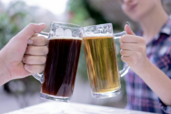 Two people doing a cheers with beers