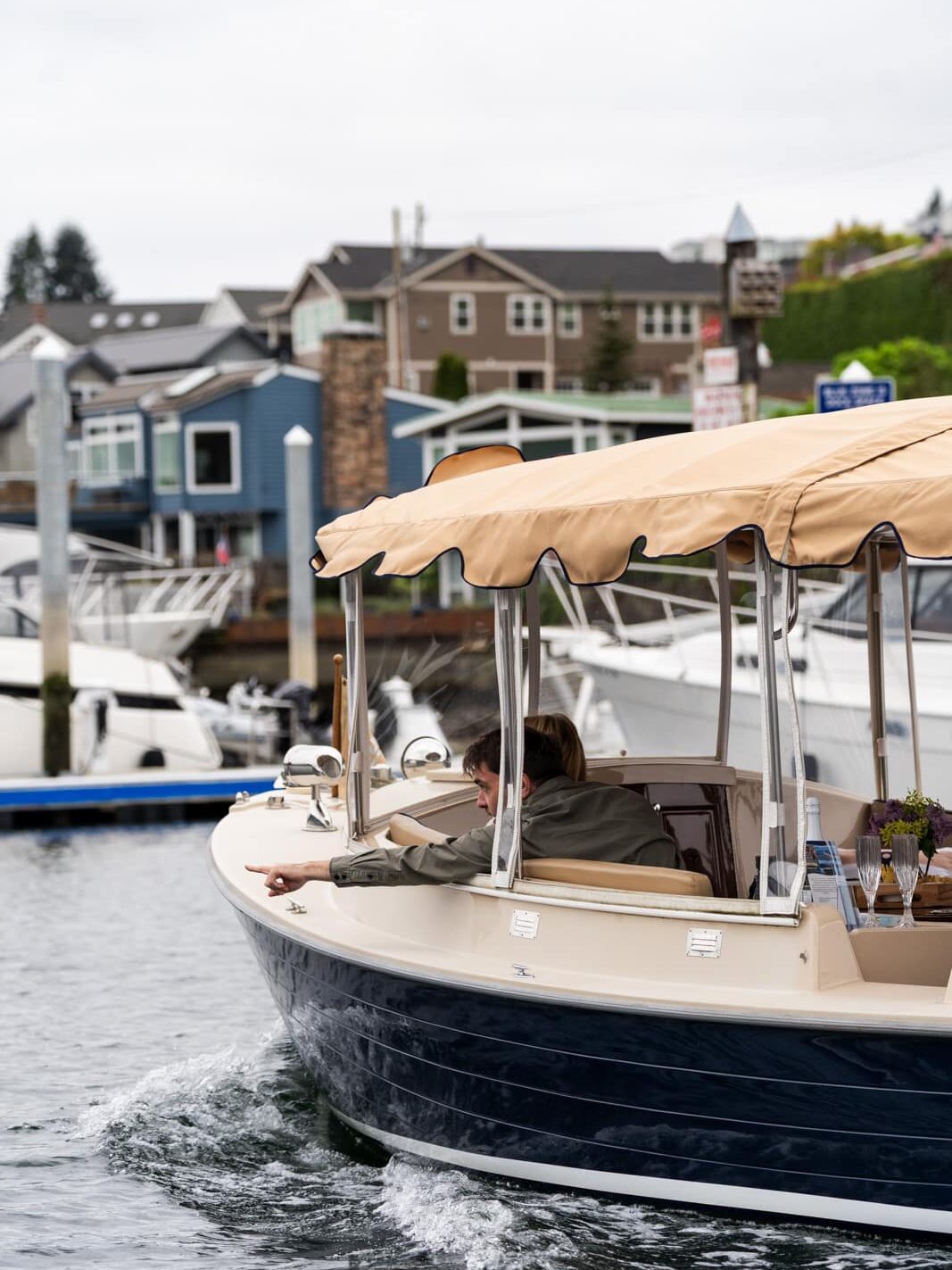 Man riding in a boat, pointing to something on the water