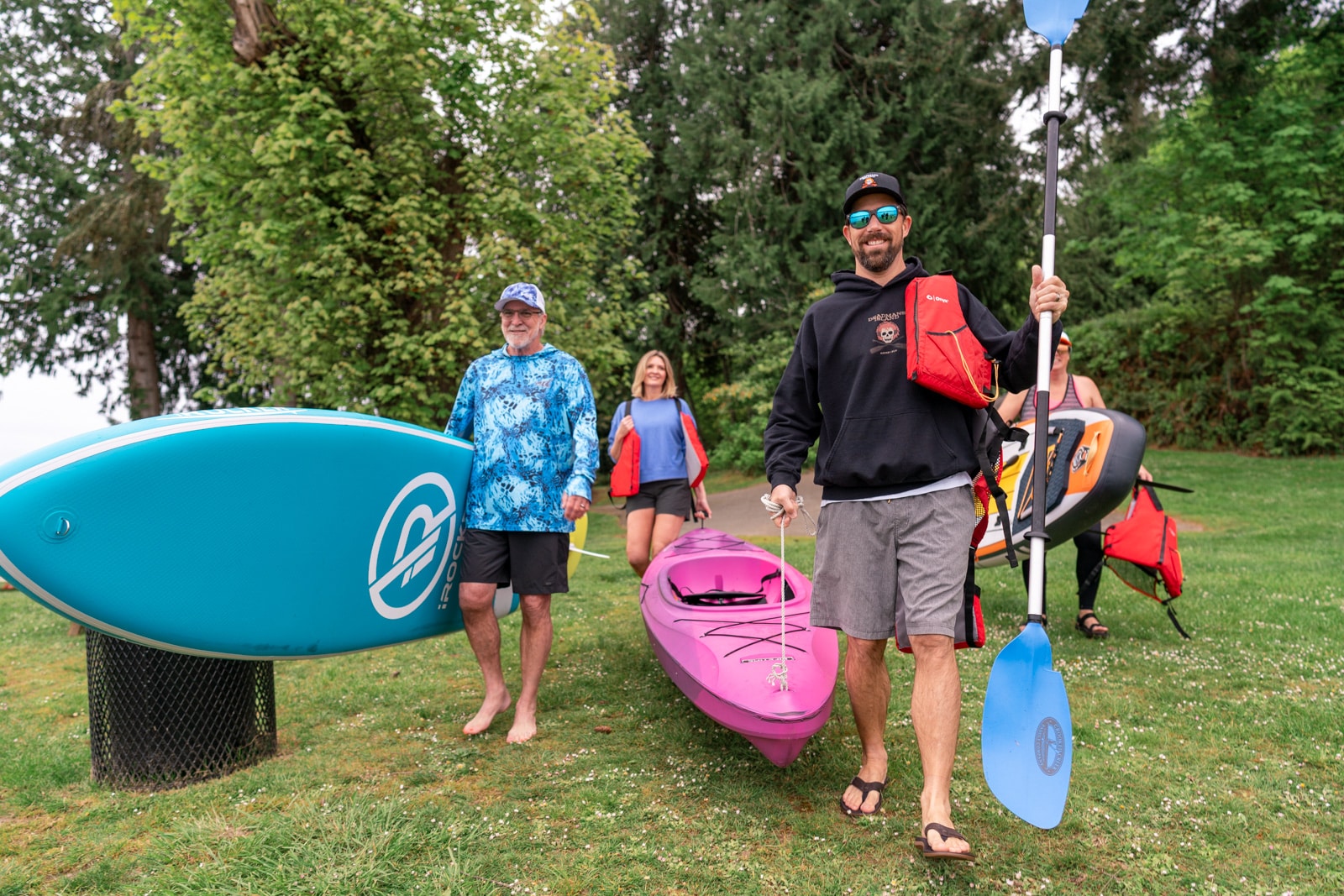 A group of people preparing to join surfing and kayak activities